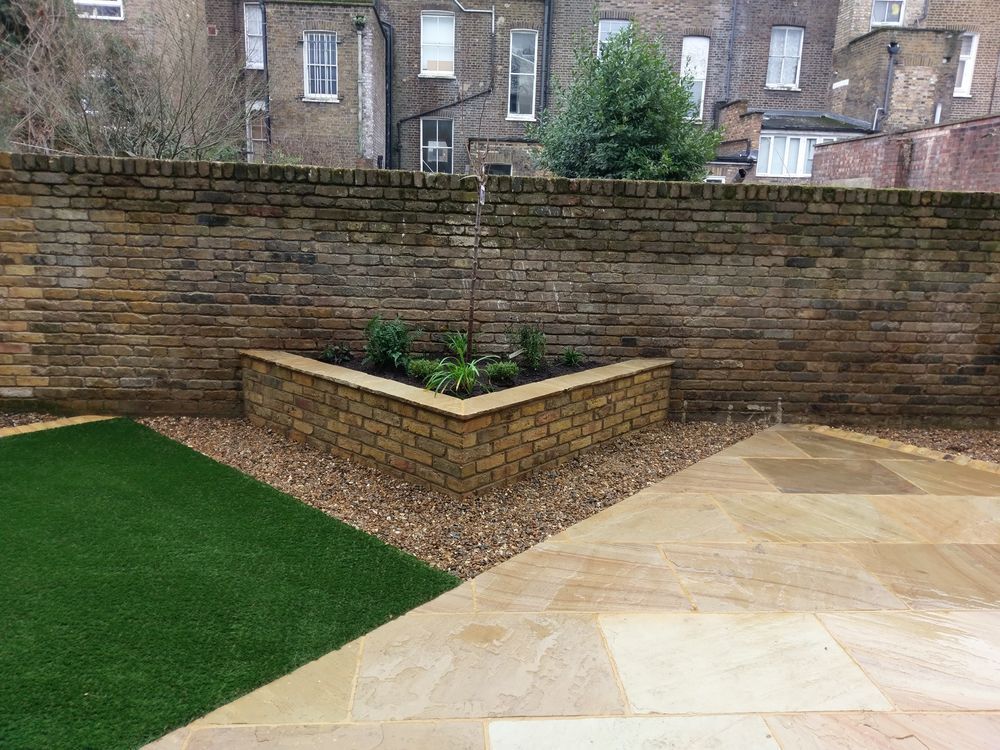 Reclaimed brick garden wall with matching raised corner planter bed
