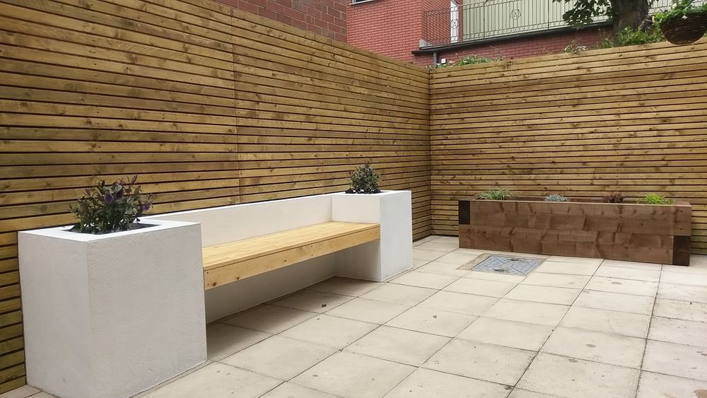 Modern courtyard with built-in timber bench and horizontal slat fencing